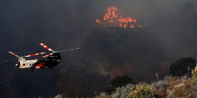 Petugas pemadam kebakaran berlomba untuk mengendalikan kebakaran hutan di LA saat angin diperkirakan akan bertiup kencang